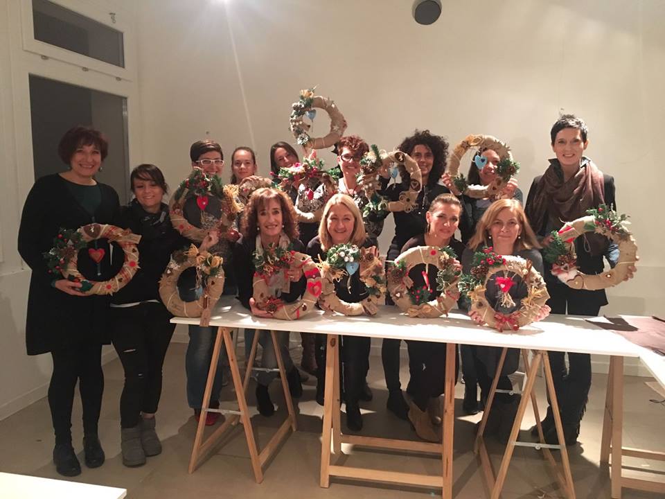 group of ladies holding Christmas wreaths