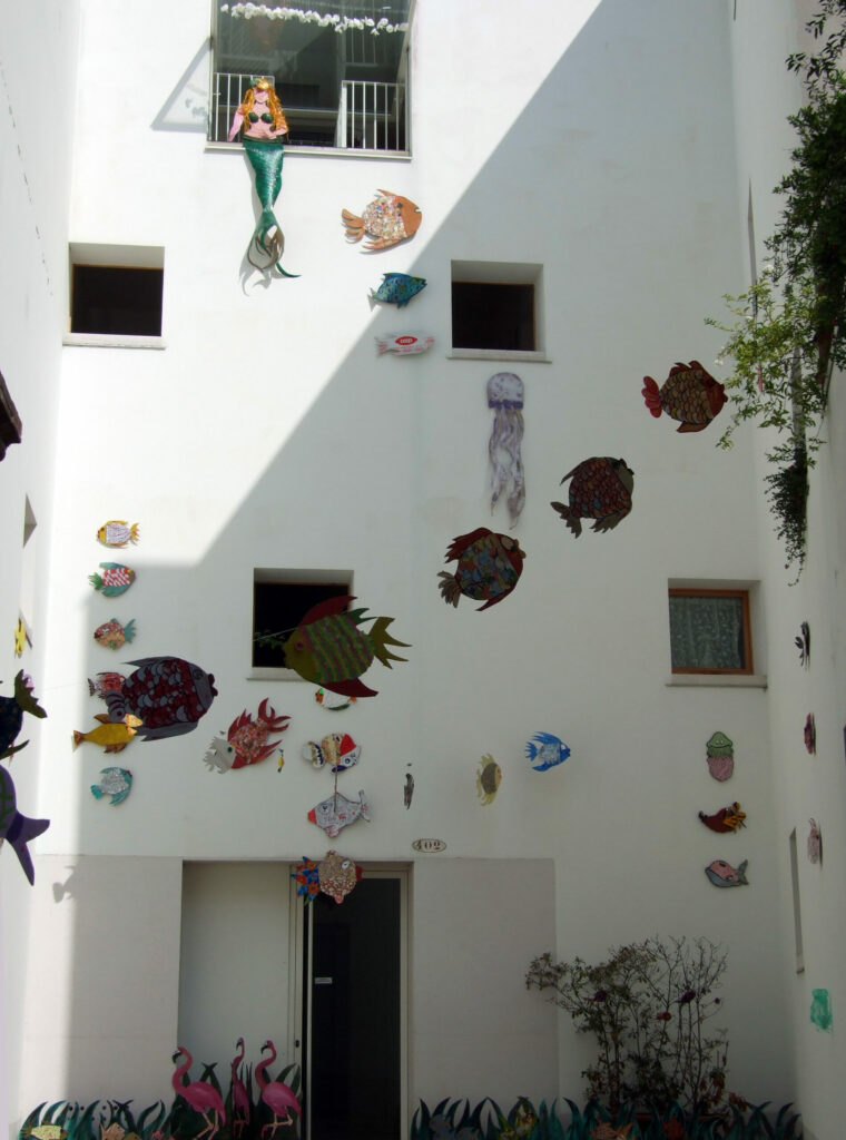 cardboard fish suspended in courtyard